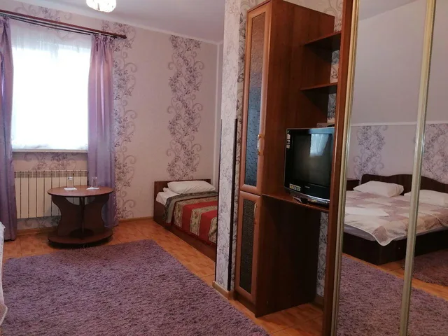 Ліжка й шафа розташовані в кімнаті з великим вікном.