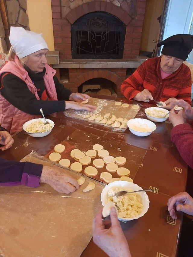 На столі рядами лежать вареники, які ліпимо разом.