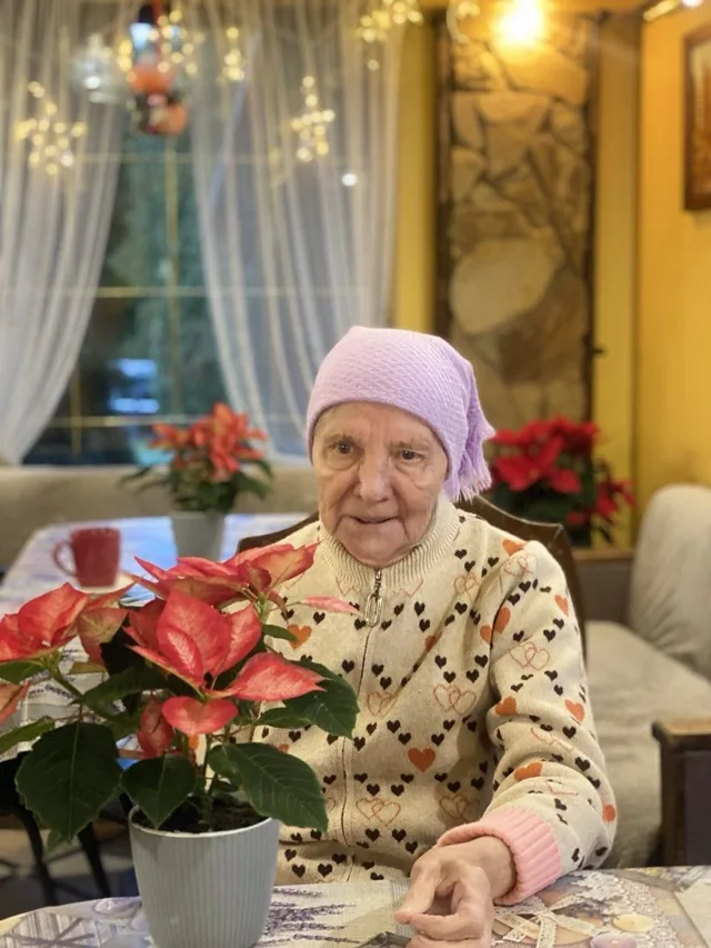 Букет червоних квітів став яскравою деталлю цього портрета.