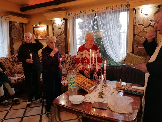 Біля святкового столу зібралася компанія для спільного привітання.