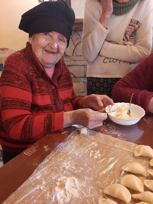 За столом ліпимо домашні вареники, розклавши перед собою тісто.