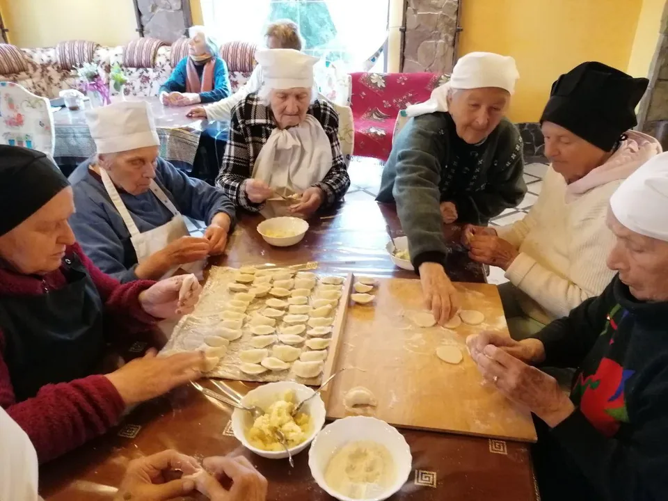 За великим столом ліпимо вареники, розклавши перед собою тісто й начинку.